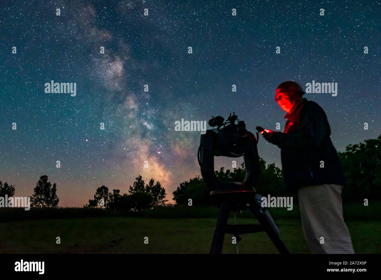 A selfie of me operating the Celestron C8 GoTo system to find targets, for a book illustration. Taken July 21, 2019 from the backyard on a very clear Stock Photo