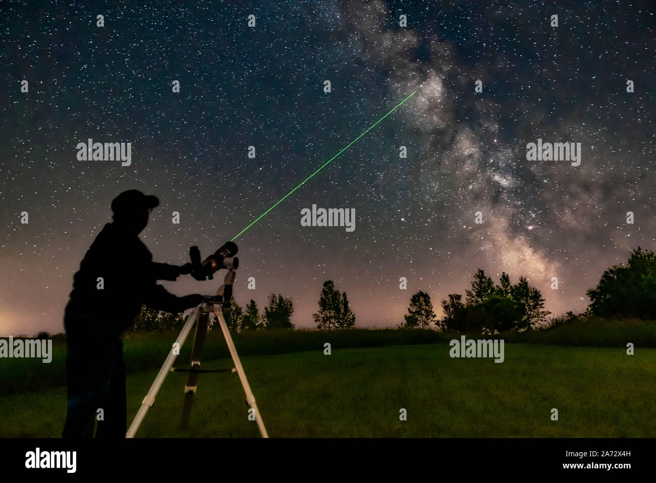 Me aiming the A&M 80mm refractor on the Astro-Tech Voyager mount at the Milky Way with its laser pointer finder showing the way. I am aiming at M11 in Stock Photo