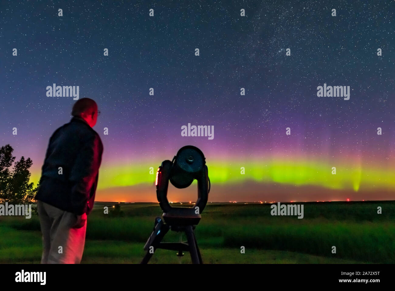 A selfie of me with the Celestron C8 telescope, with an aurora in the north, for a book illustration. Taken July 21, 2019 from the backyard on a very Stock Photo