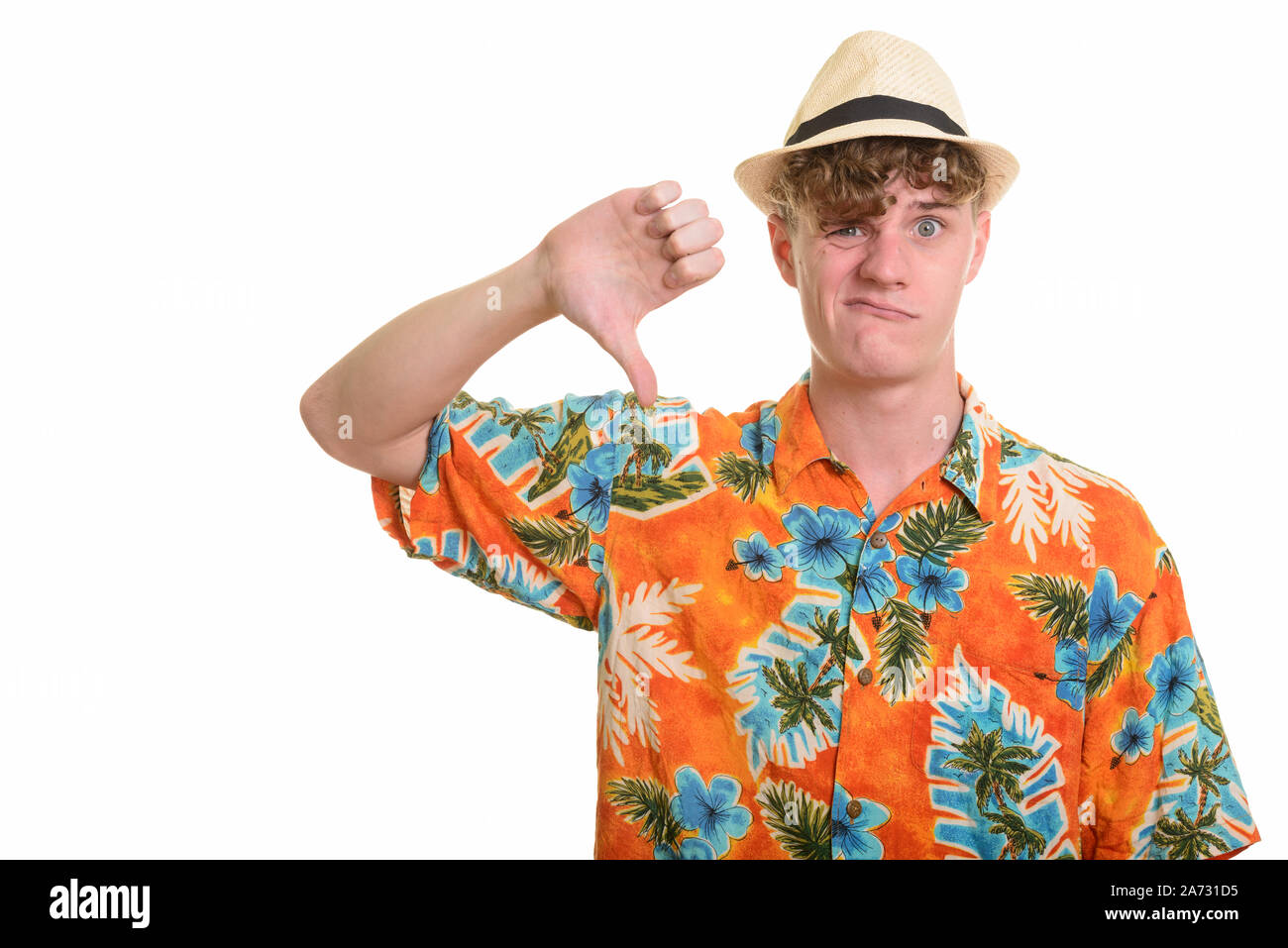 Stressed young tourist man with hat giving thumbs down for vacation Stock Photo