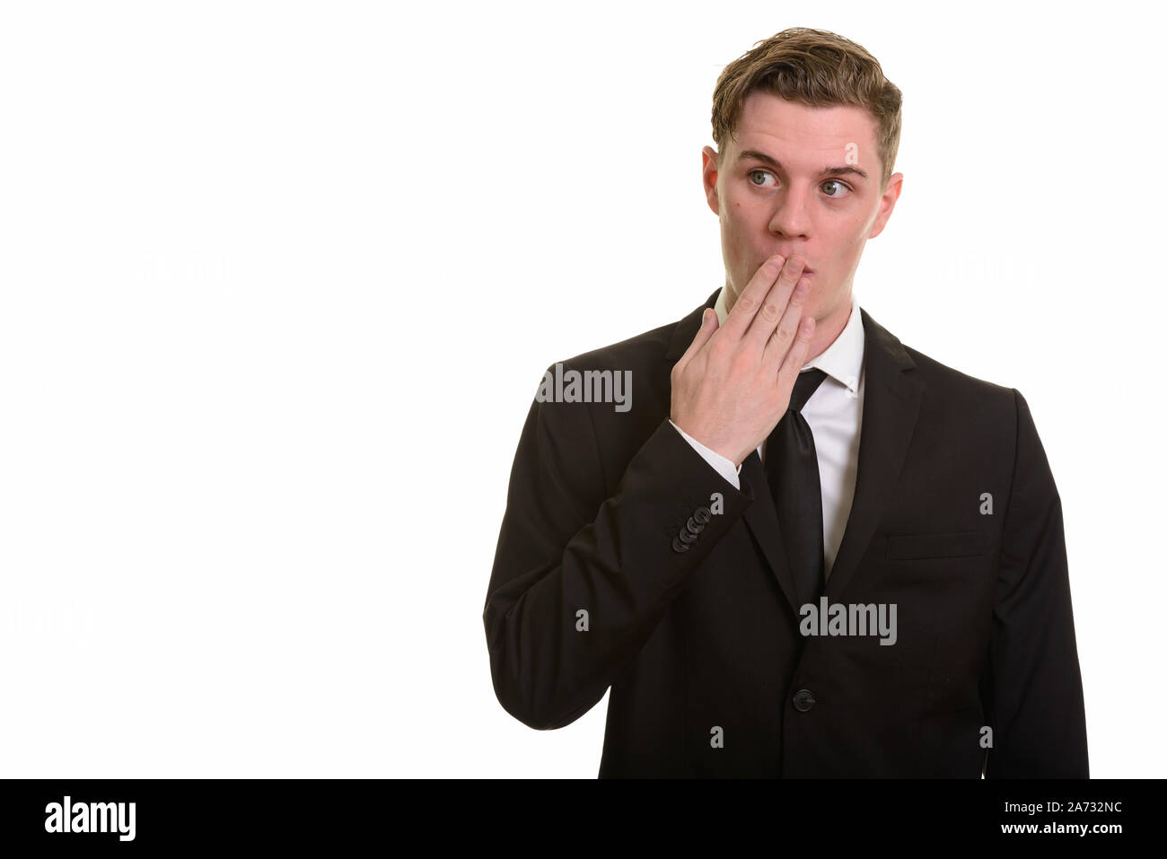 Young handsome blonde businessman in suit looking shocked Stock Photo