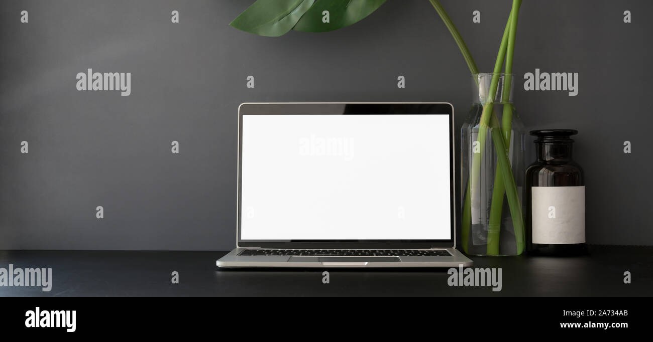 Open blank screen laptop computer in dark trendy workplace with copy ...