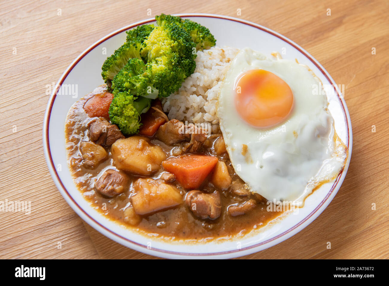 Chicken curry Rice on wooden background ( Poached egg, Potato, enoki