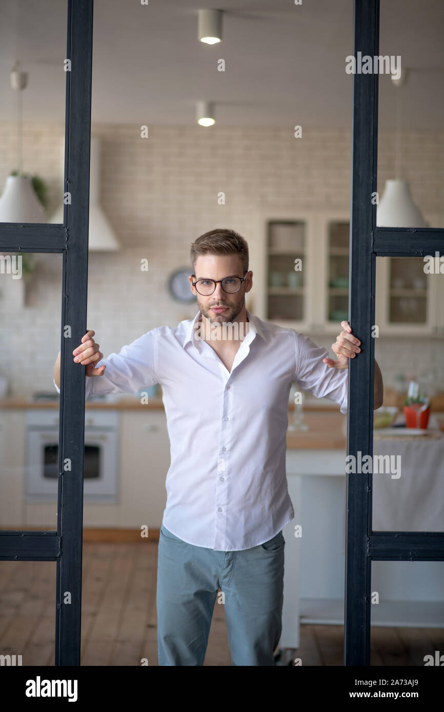Serious businessman opening glass door to living room Stock Photo Alamy