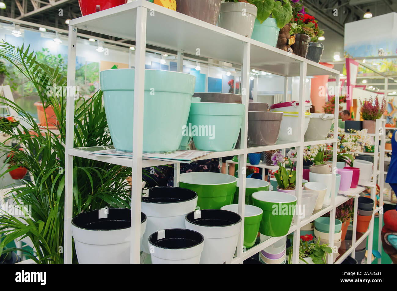 Ceramic multi-colored pots and vases for flowers on white shelves in ...