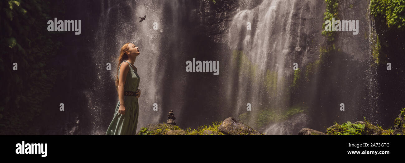 Woman in turquoise dress at the Sekumpul waterfalls in jungles on Bali ...
