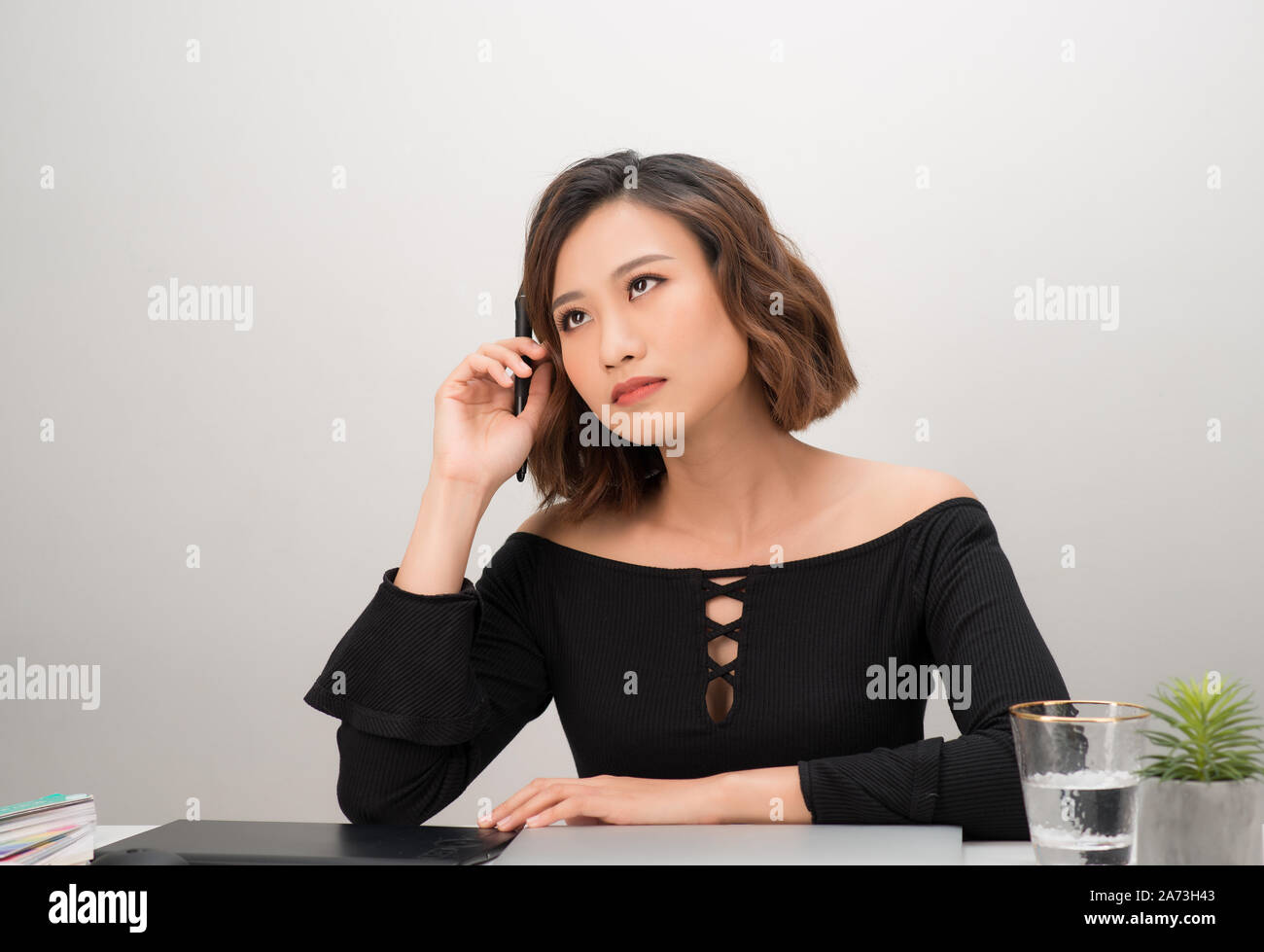 Asian girl graphic designer thinking idea for a new project, freelancer thinking idea for a new project in selective focus. Stock Photo