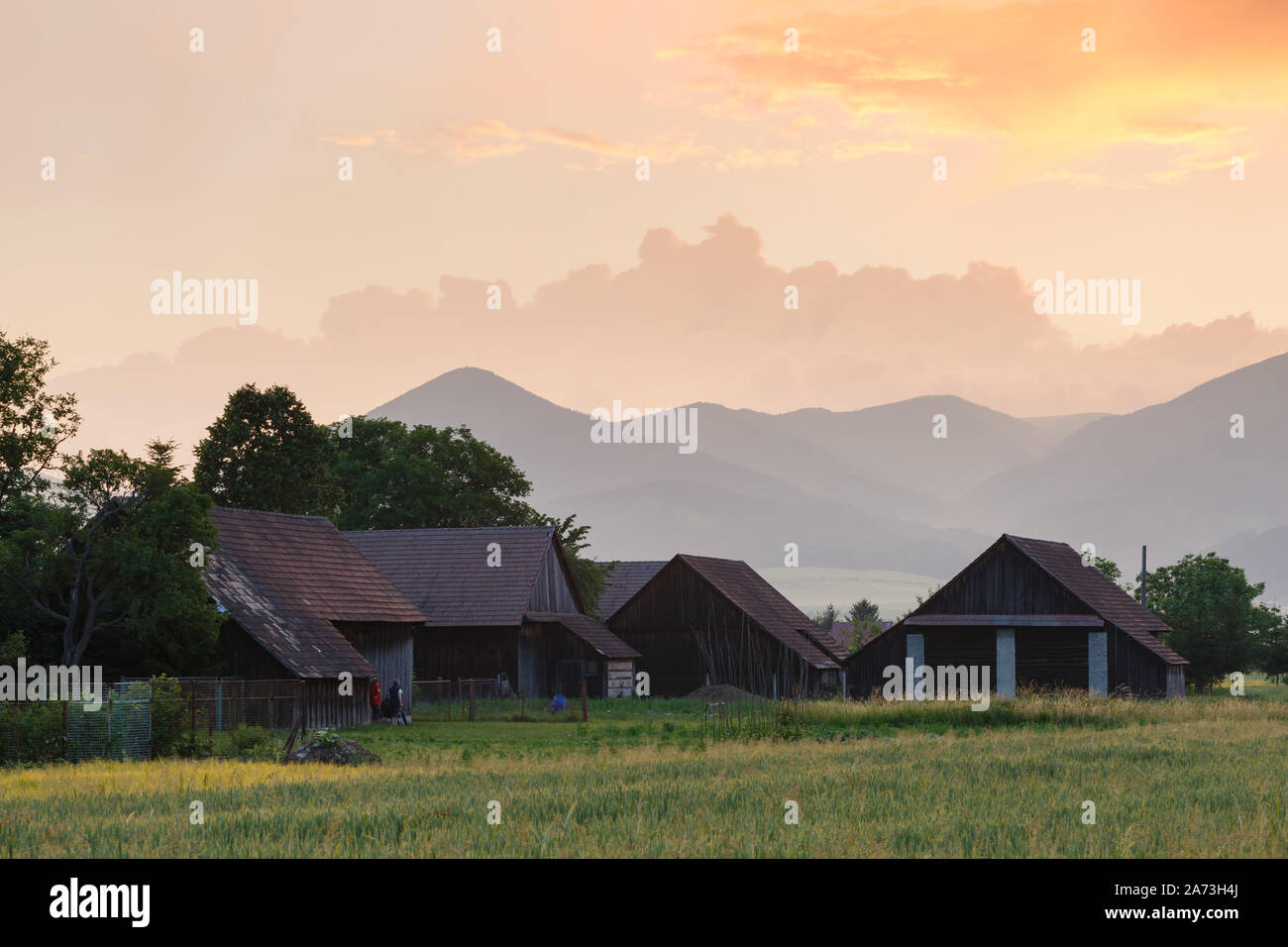 Clearing storm over a rural landscape with a traditional barn in Turiec region, central Slovakia. Stock Photo