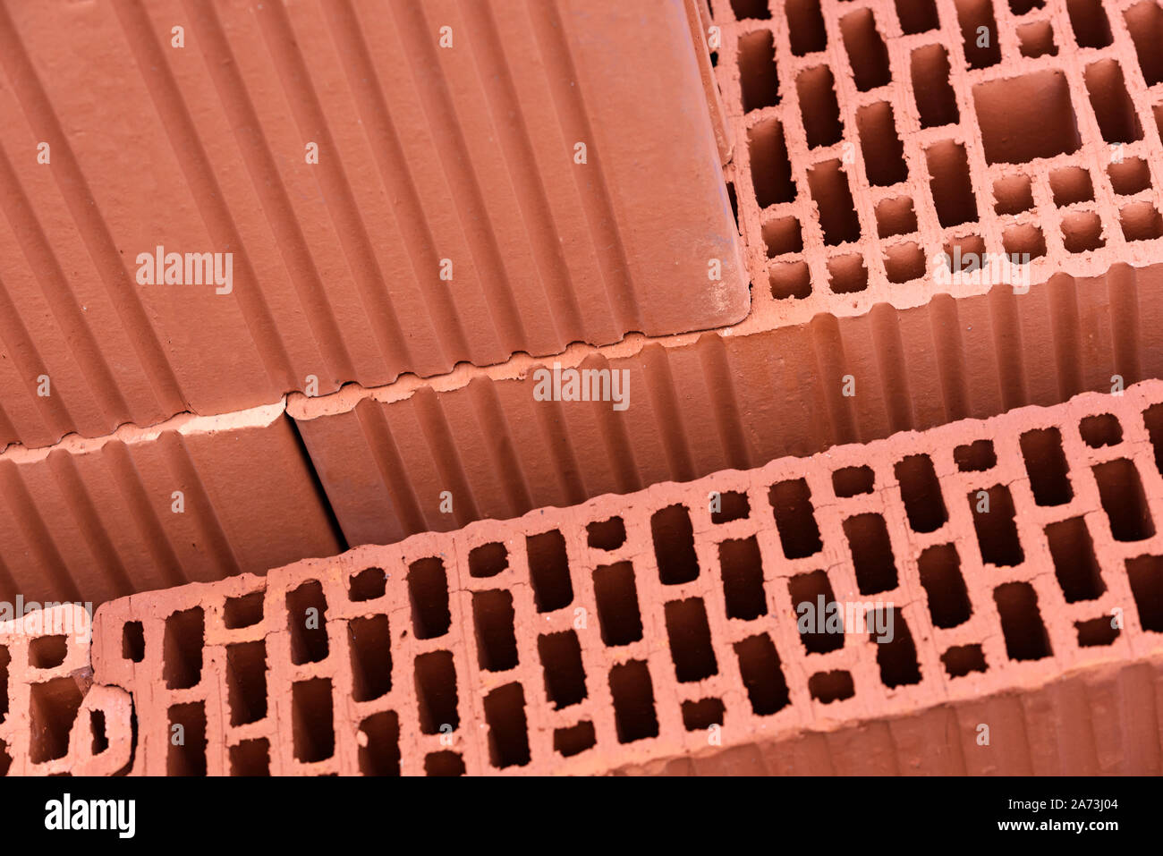 Modern construction industry concept - thermo isolated red bricks for building wall in close-up. Stock Photo