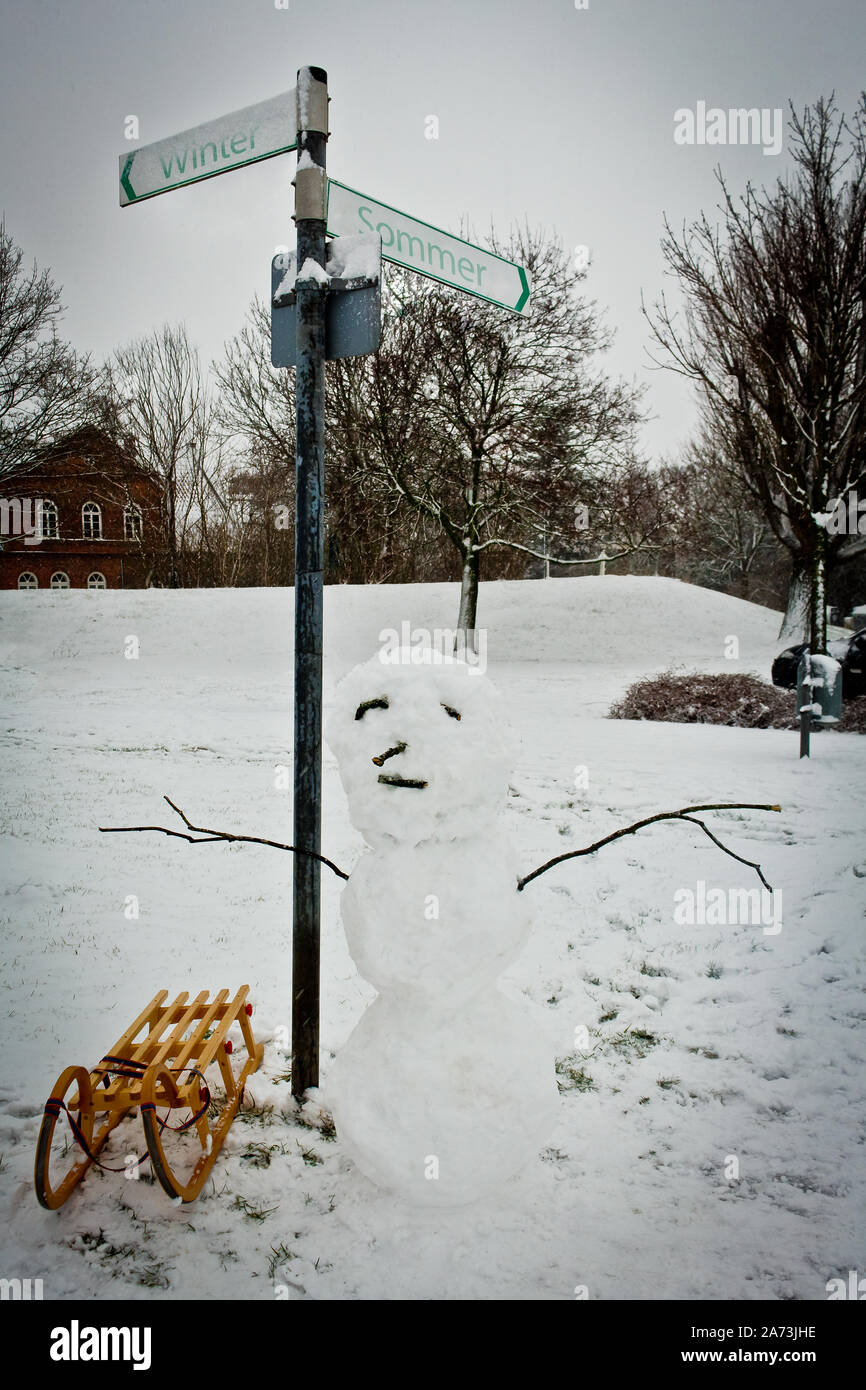 Sign in winter. Snowman with sledge and signage "Winter or Summer" Stock Photo