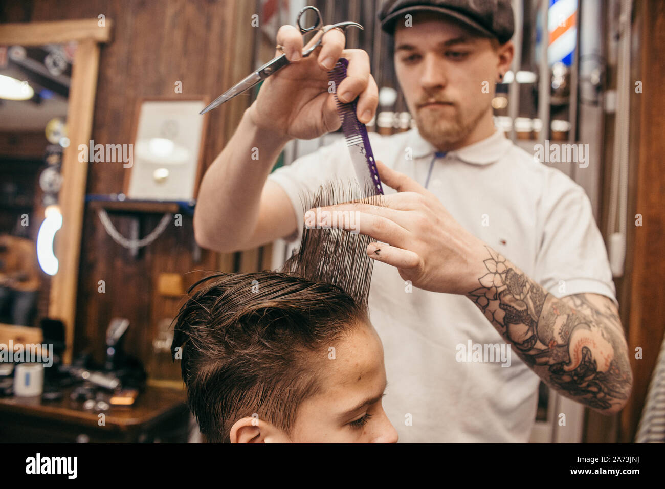 Teenage boy haircuts hairdresser in the Barber shop. Fashionable ...