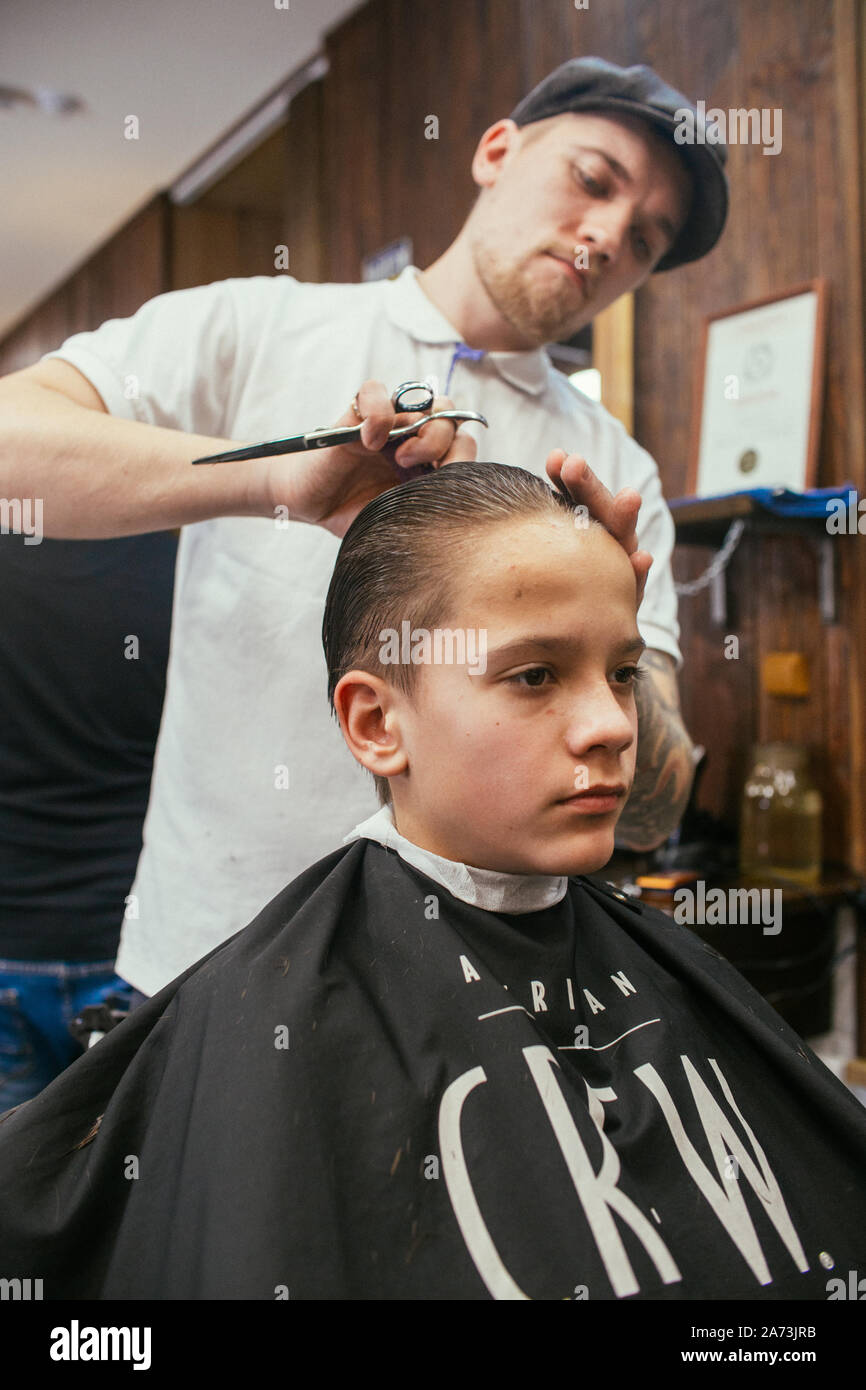 Teenage boy haircuts hairdresser in the Barber shop. Fashionable stylish  retro hairstyle. Portrait of a child with a beautiful haircut. Russia,  Sverdl Stock Photo - Alamy