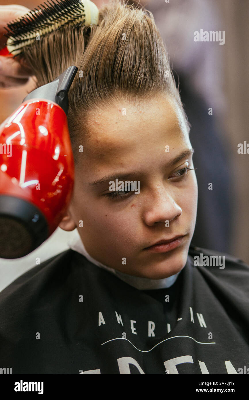 Teenage boy haircuts hairdresser in the Barber shop. Fashionable stylish  retro hairstyle. Portrait of a child with a beautiful haircut. Russia,  Sverdl Stock Photo - Alamy