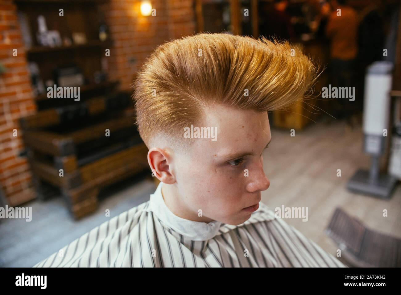 Teenage redhead boy haircuts hairdresser in the Barber shop. Fashionable  stylish retro hairstyle. Portrait of a child with a beautiful haircut.  Russia Stock Photo - Alamy