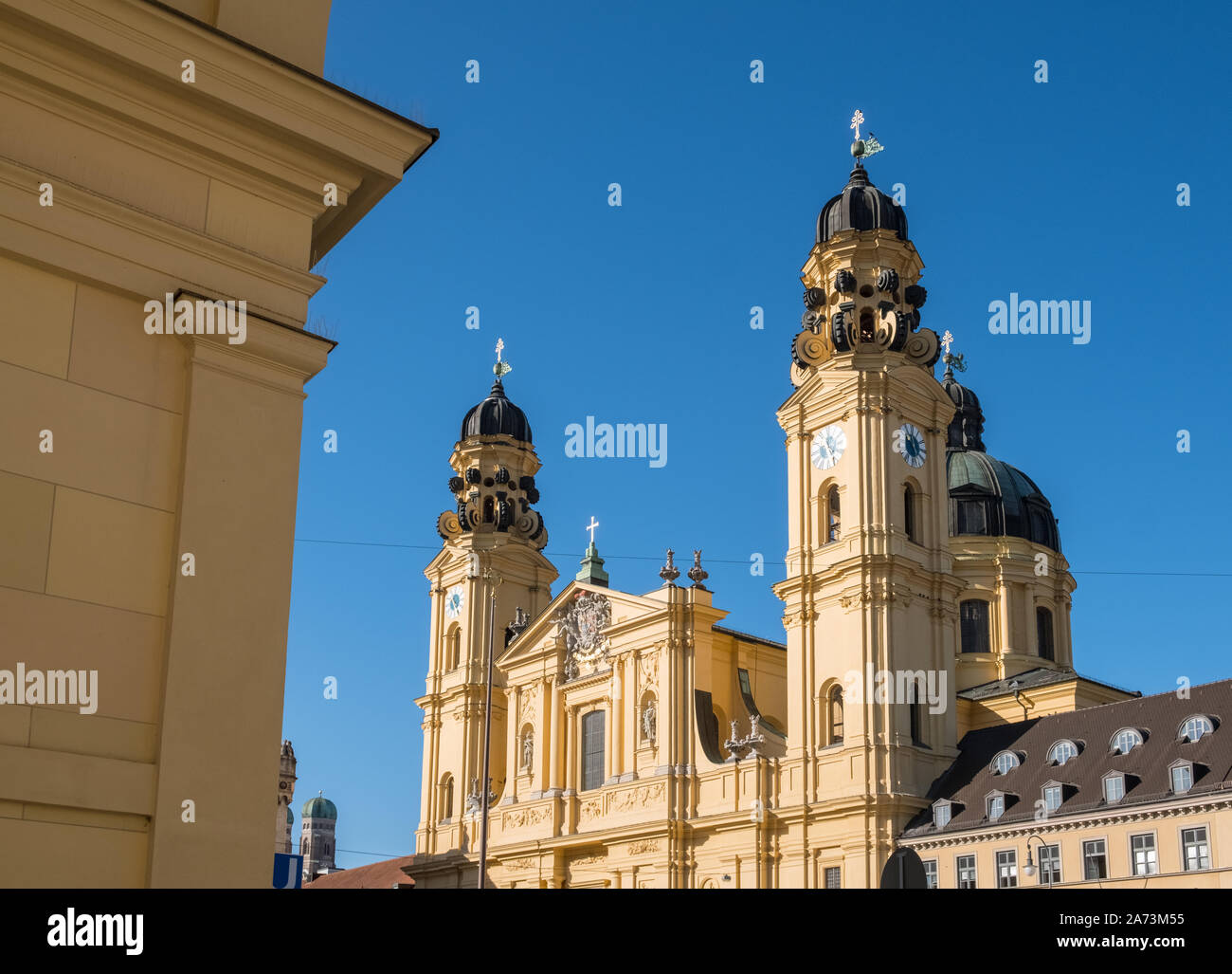 Old Town, Munich, Germany. Landmark domes of yellow building Theatine Church, a Roman Catholic church with a baroque architecture exterior. Stock Photo