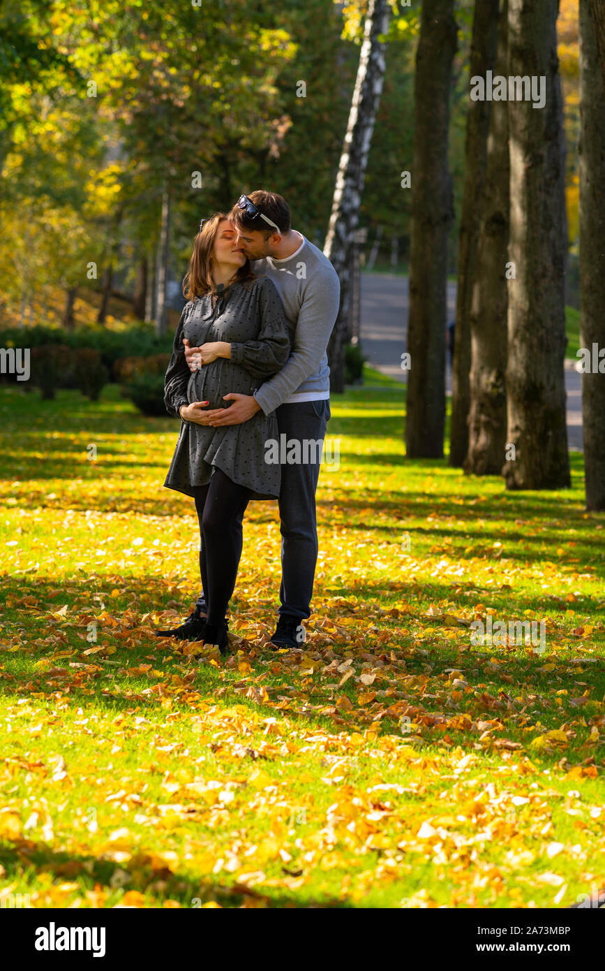 Trendy romantic young couple kissing in the park in autumn as they ...