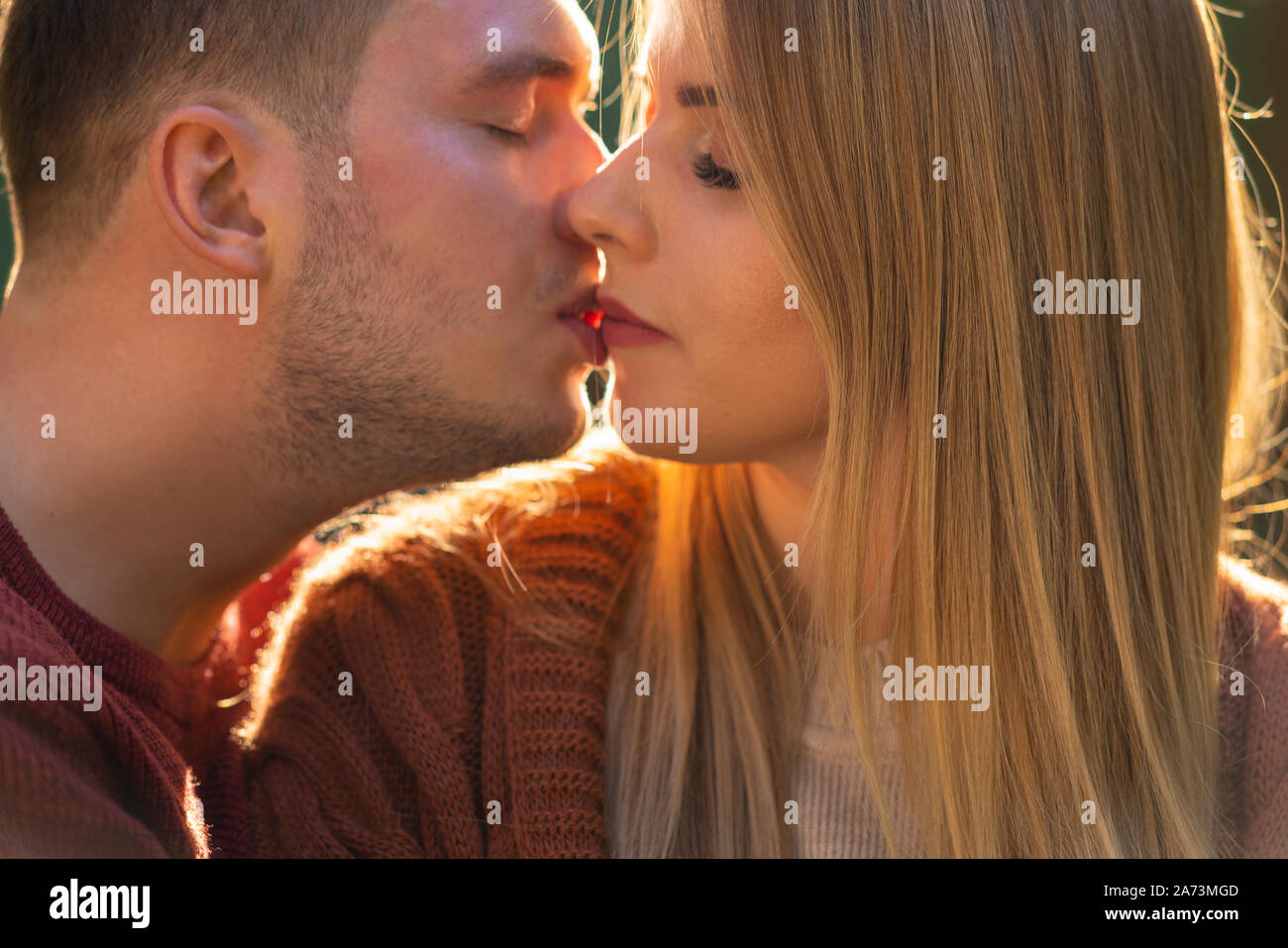 Young couple in love enjoying a tender kiss in a close up on their faces as their lips touch Stock Photo