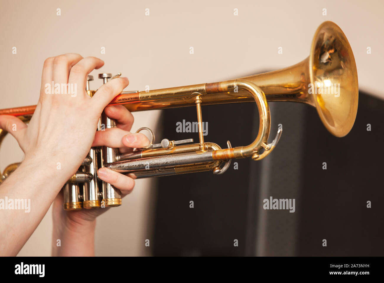 Trumpet in trumpeter hands. It is a brass instrument commonly used in classical and jazz ensembles, close-up photo with selective focus Stock Photo