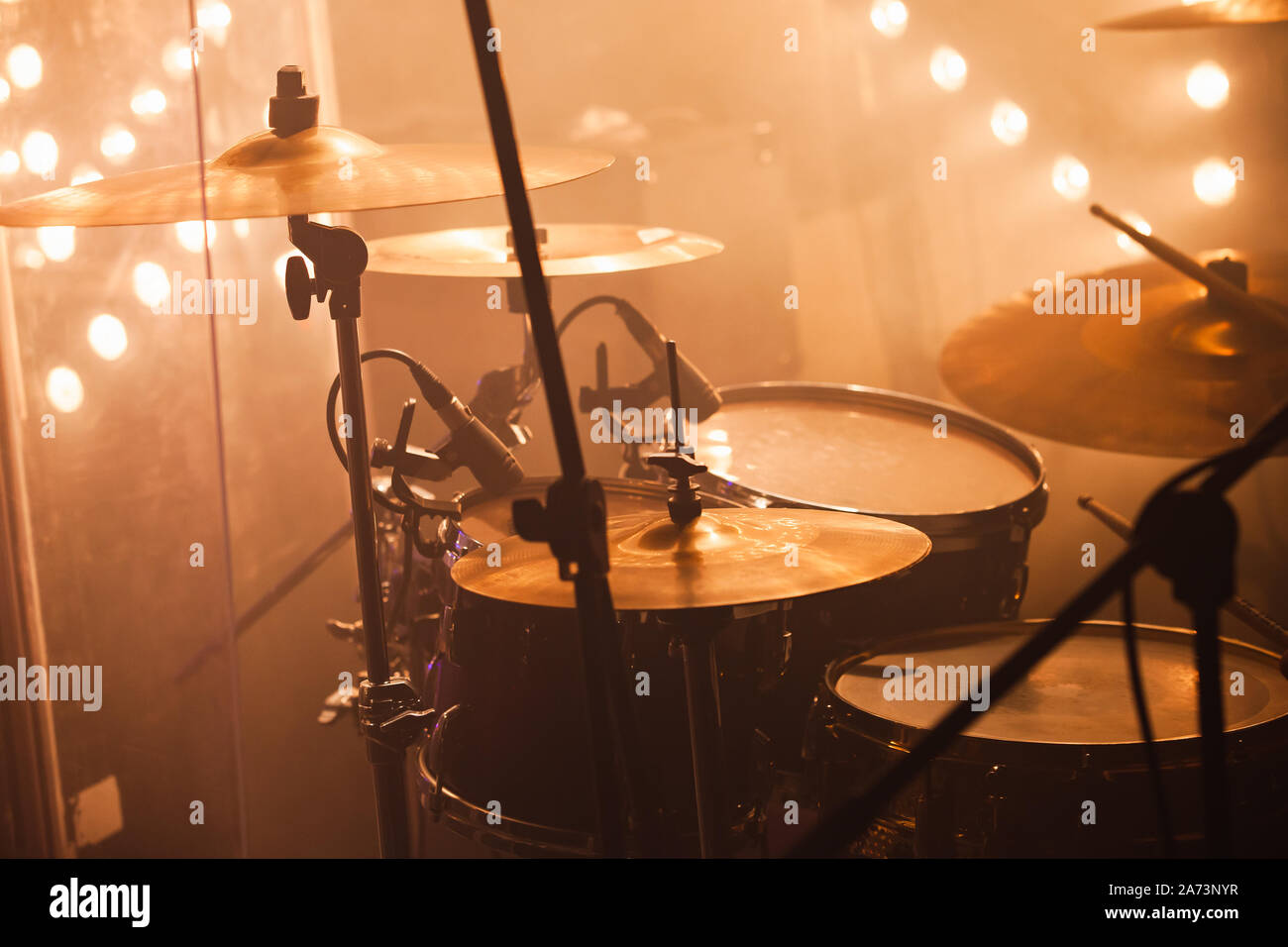 Rock band drum set with cymbals stands on a stage with strobe lights Stock Photo
