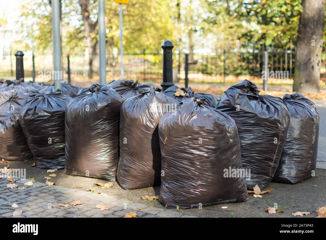 Many black plastic garbage bags outside. Plastic bag for waste