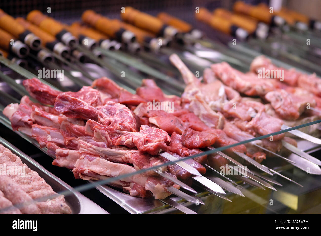 Semi finished meat products on skewers in stores fridge. Meat steaks