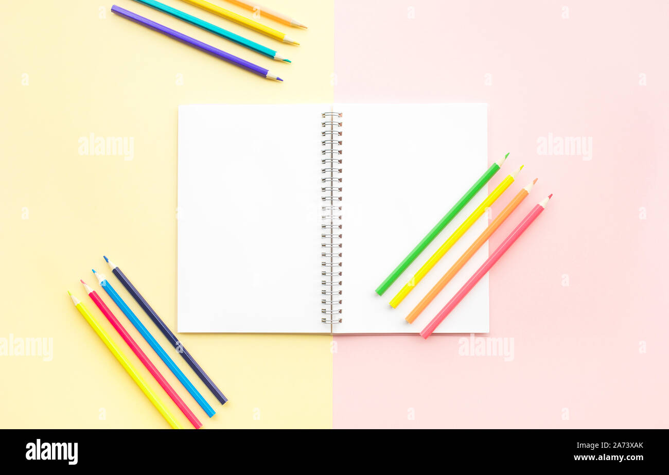 Top view of colorful  pencil on white notepaper on color pastel background.graphic design for flat lay visual.education and back to school of kids Stock Photo