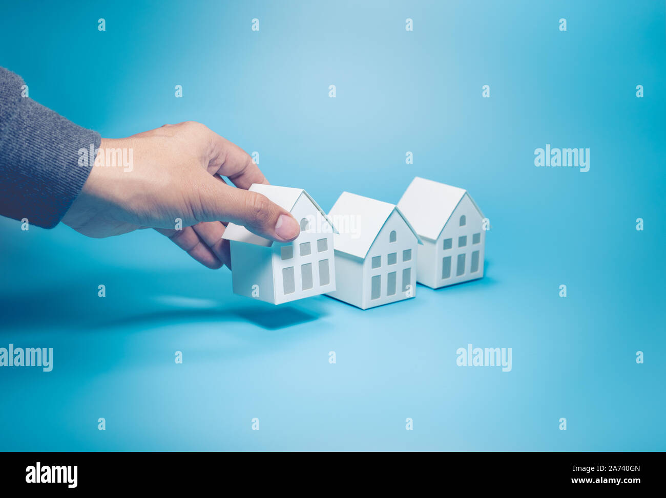 Business property,real estate and investment concepts with male hand and  white model house on pastel color background Stock Photo - Alamy