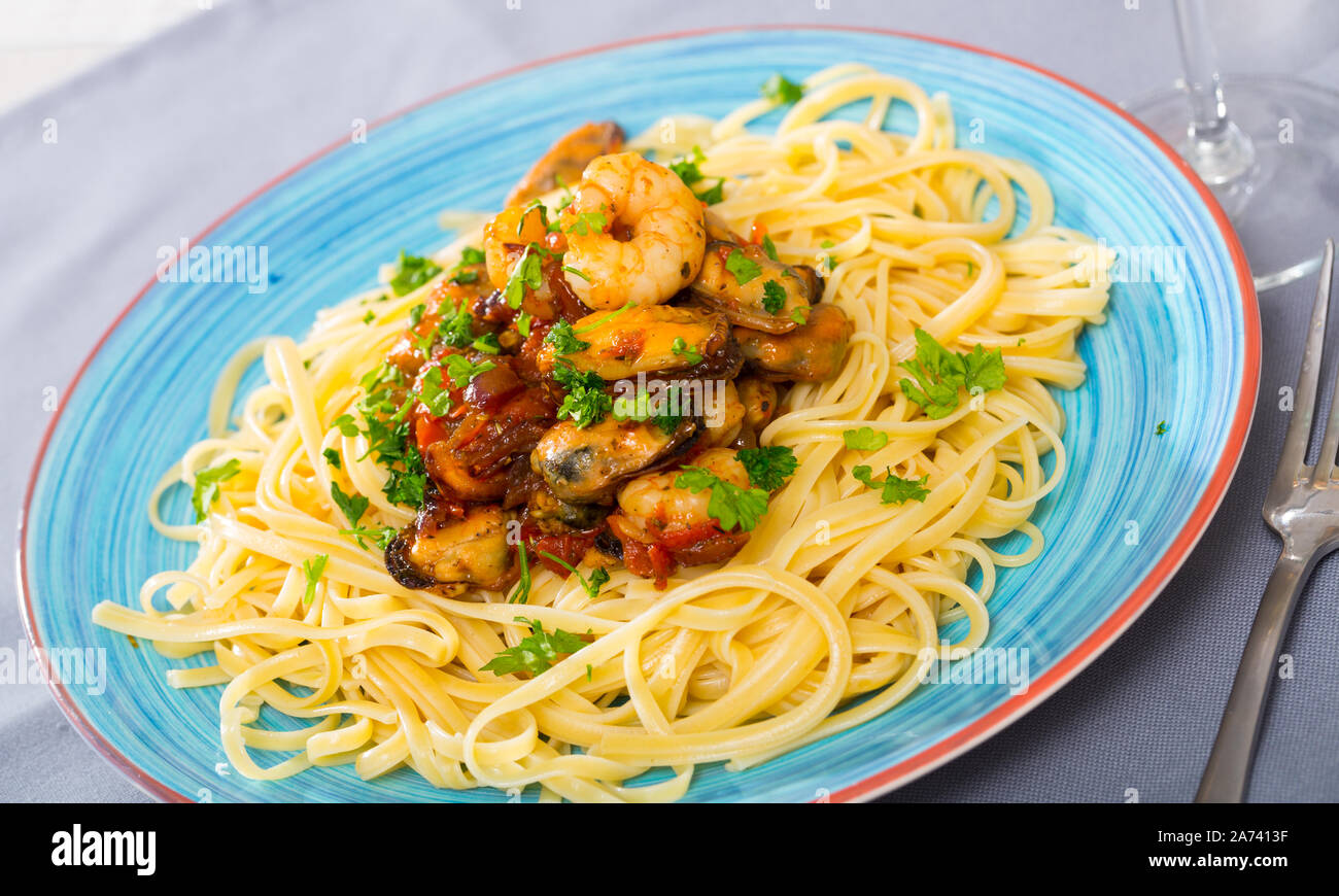 Traditional Italian seafood cuisine. Pasta with shrimps and mussels