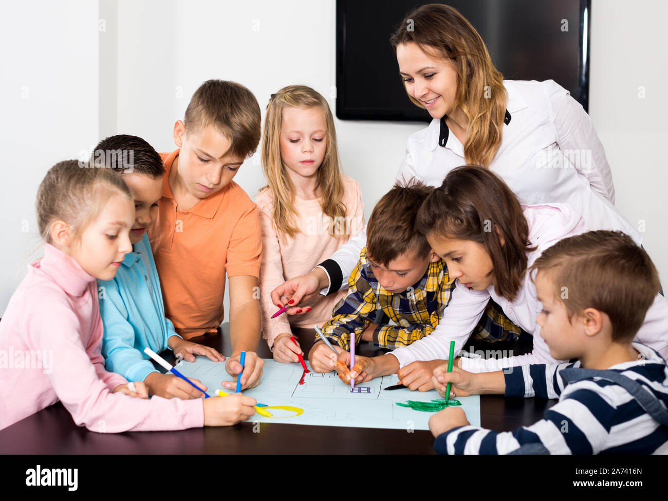 Cheerful team of elementary age children drawing on one sheet Stock ...