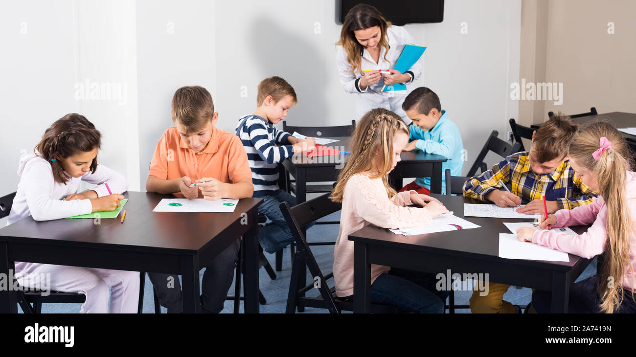 Little children with professional teacher drawing in classroom on the ...