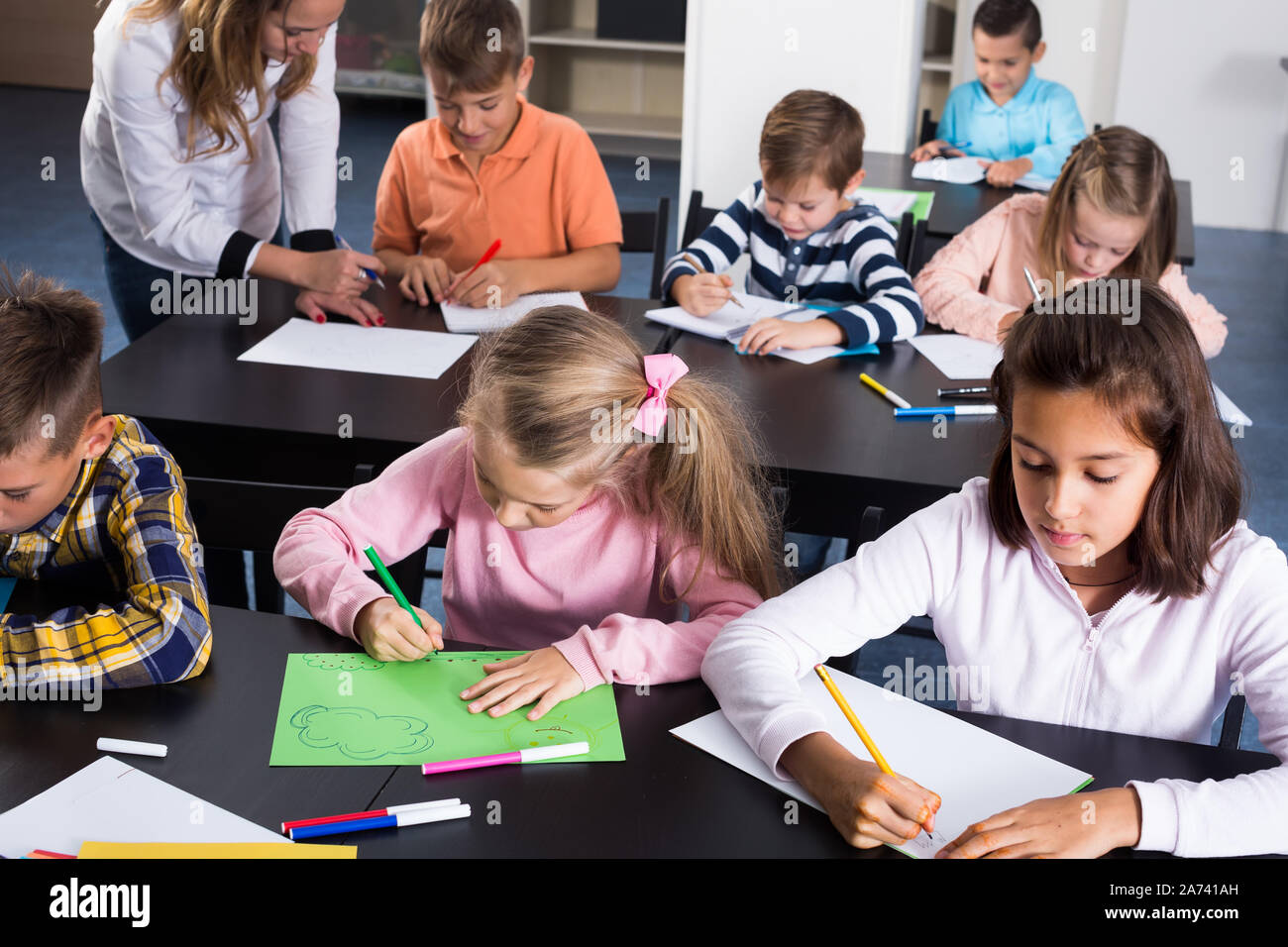 Portrait of smiling children in elementary age drawing at class Stock ...