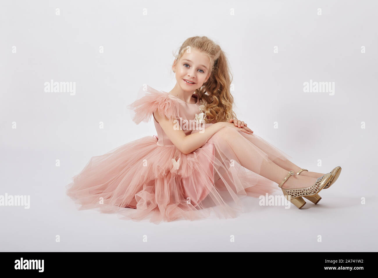 Young girl miss beauty in a beautiful dress. Children's cosmetics and makeup.  Girl posing on a light background. Funny emotions and surprise. Russia  Stock Photo - Alamy