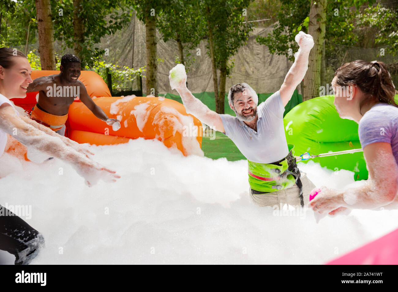 Game of funny friends in soap suds on an inflatable trampoline Stock Photo  - Alamy