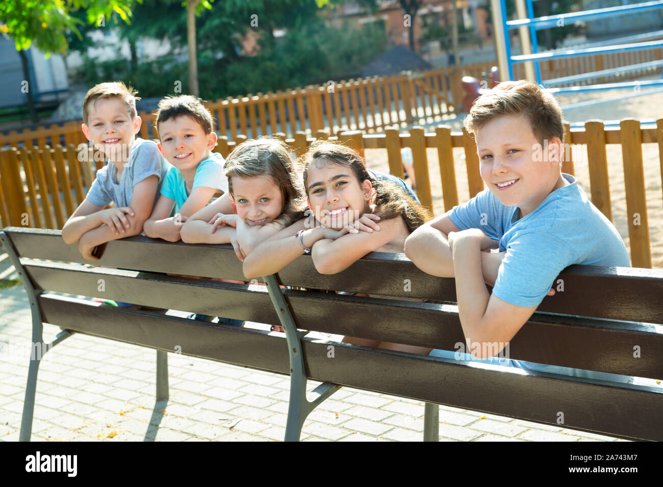 Five children sitting on bench at the playground Stock Photo - Alamy