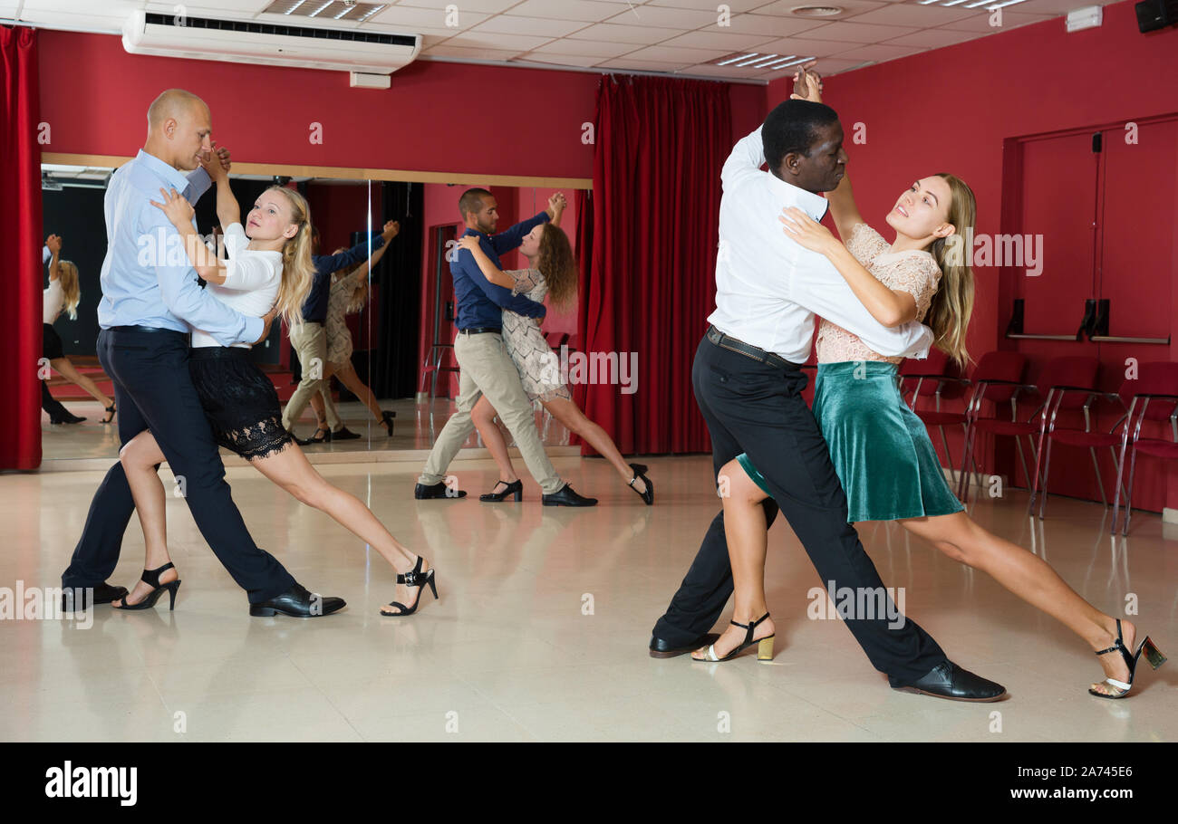 Young smiling people practicing passionate samba in dance class Stock Photo