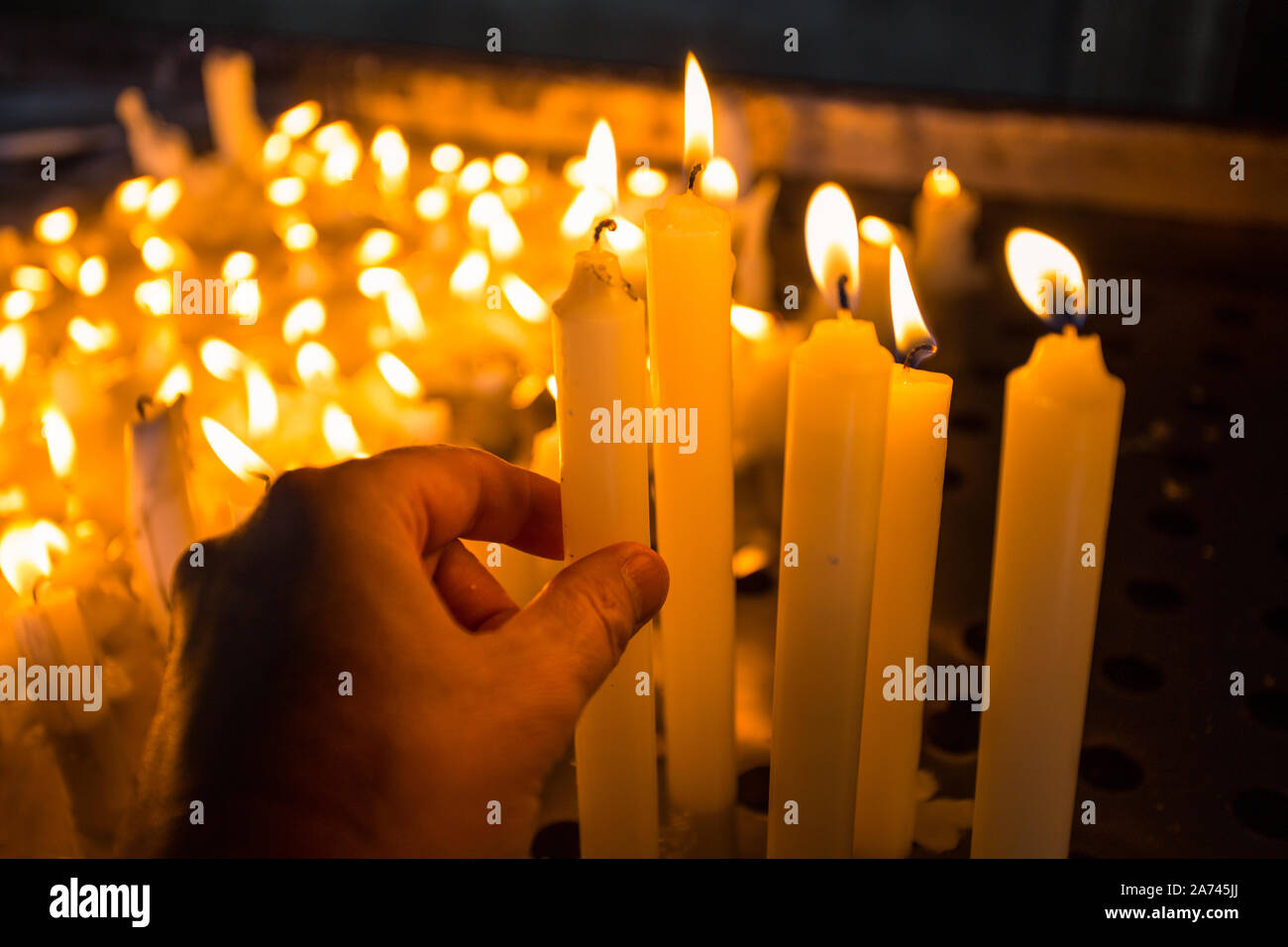 Hand lighting a candle in the church Stock Photo Alamy