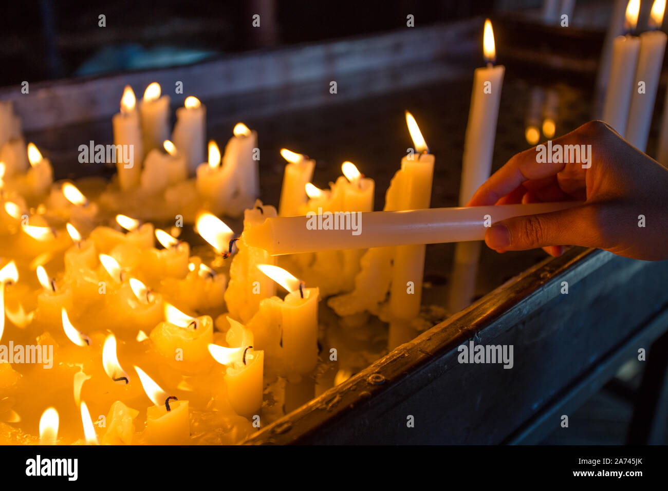 Hand lighting a candle in the church Stock Photo Alamy