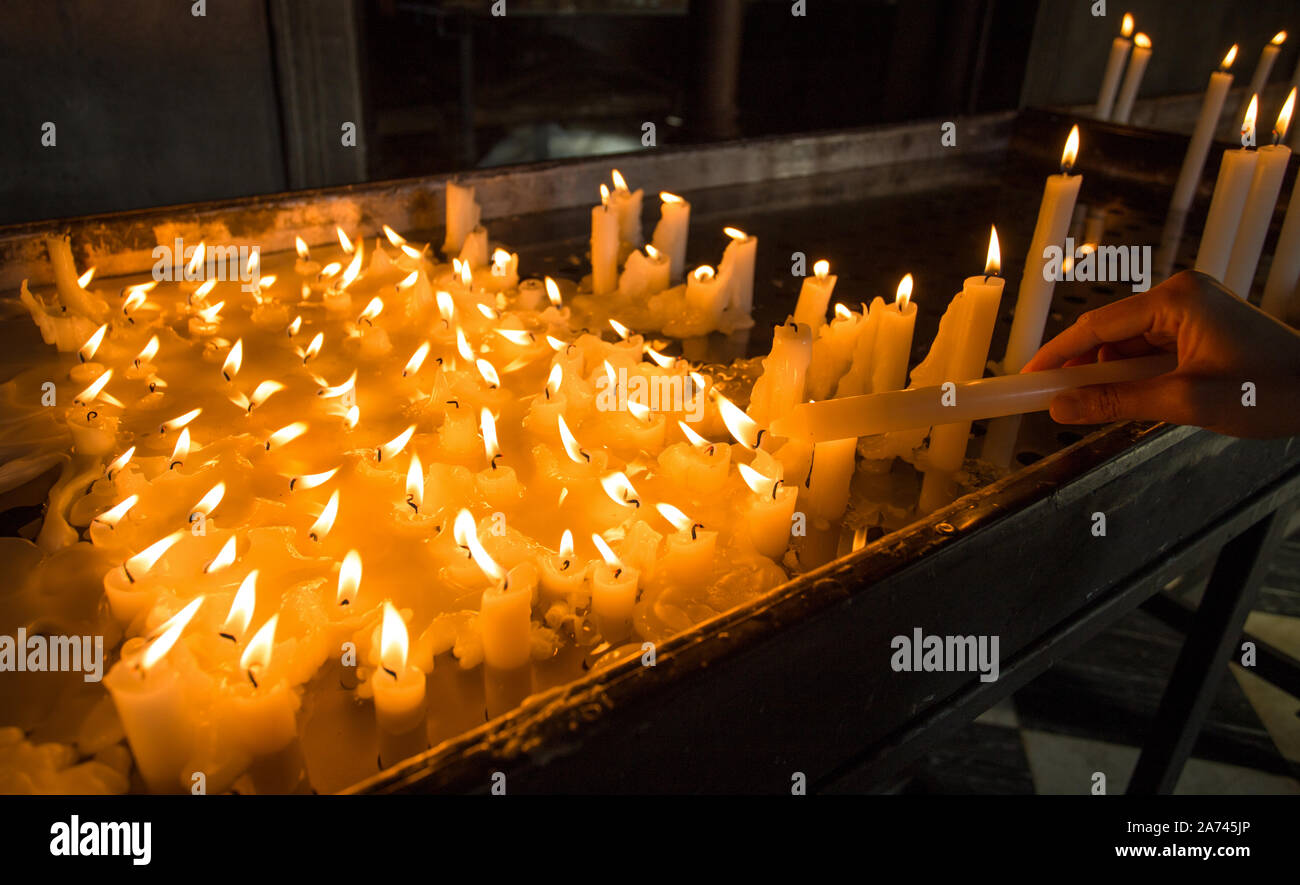 Hand lighting a candle in the church Stock Photo Alamy