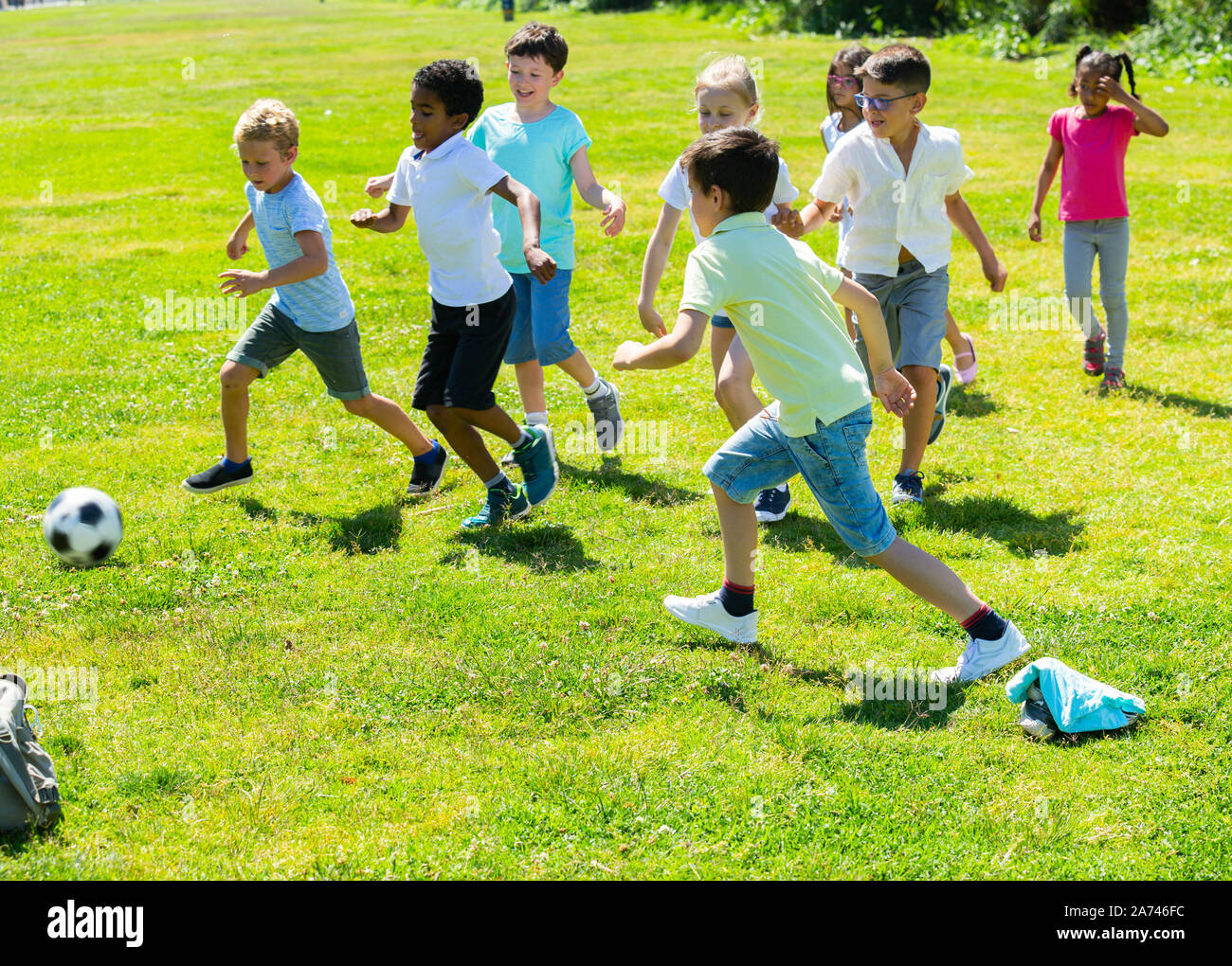 мальчики играют в футбол в парке. Schoolboy walking with family. играющие дети. прогулки на свежем воздухе для детей. мальчики играют в футбол в парке.