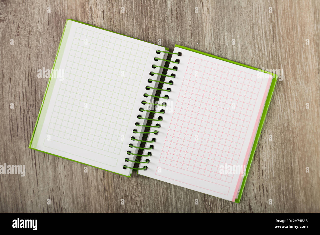 Open notebook lying on wooden surface Stock Photo