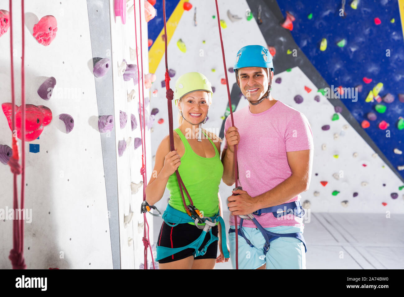 Two smiling confident athletes in mountaineering outfit ready for
