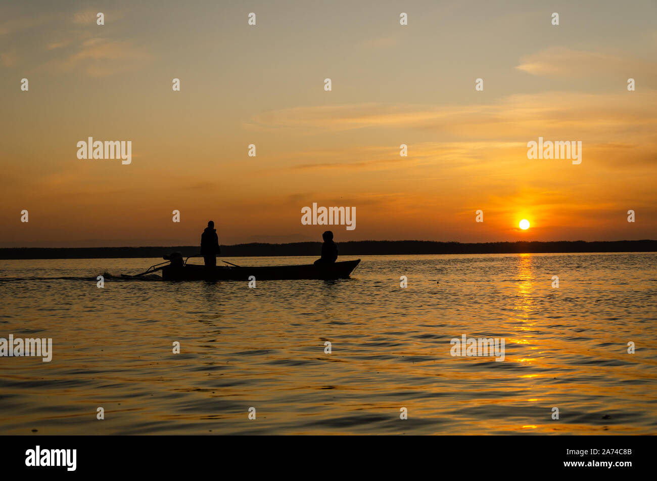 The fishermen and boat silhouette on the lake Stock Photo - Alamy