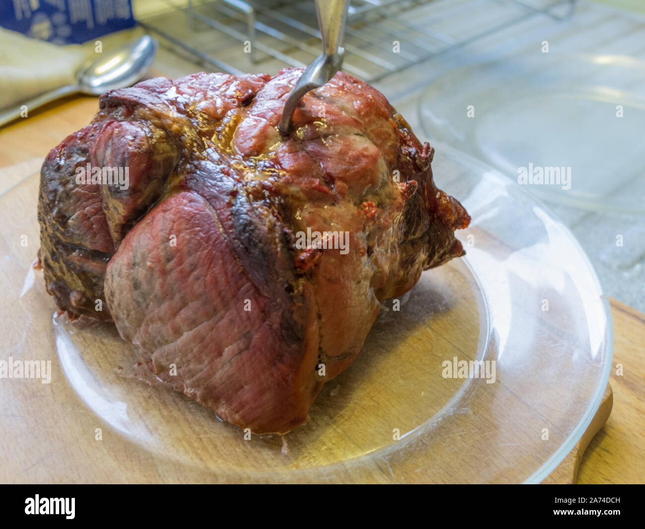 Steaming hot roasted joint of beef ready for carving before a Sunday