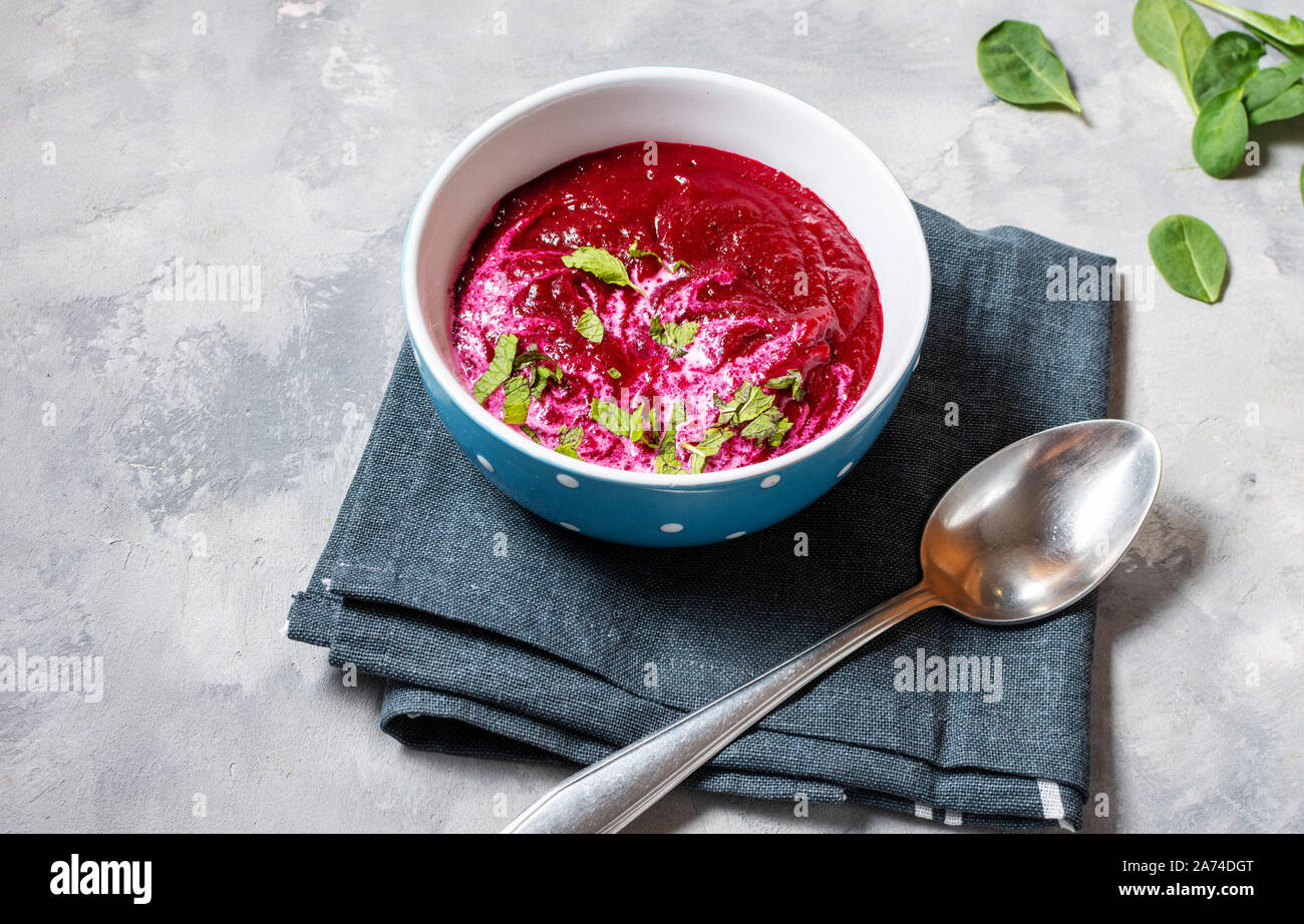 Soup of pureed red beets on concrete background. Stock Photo
