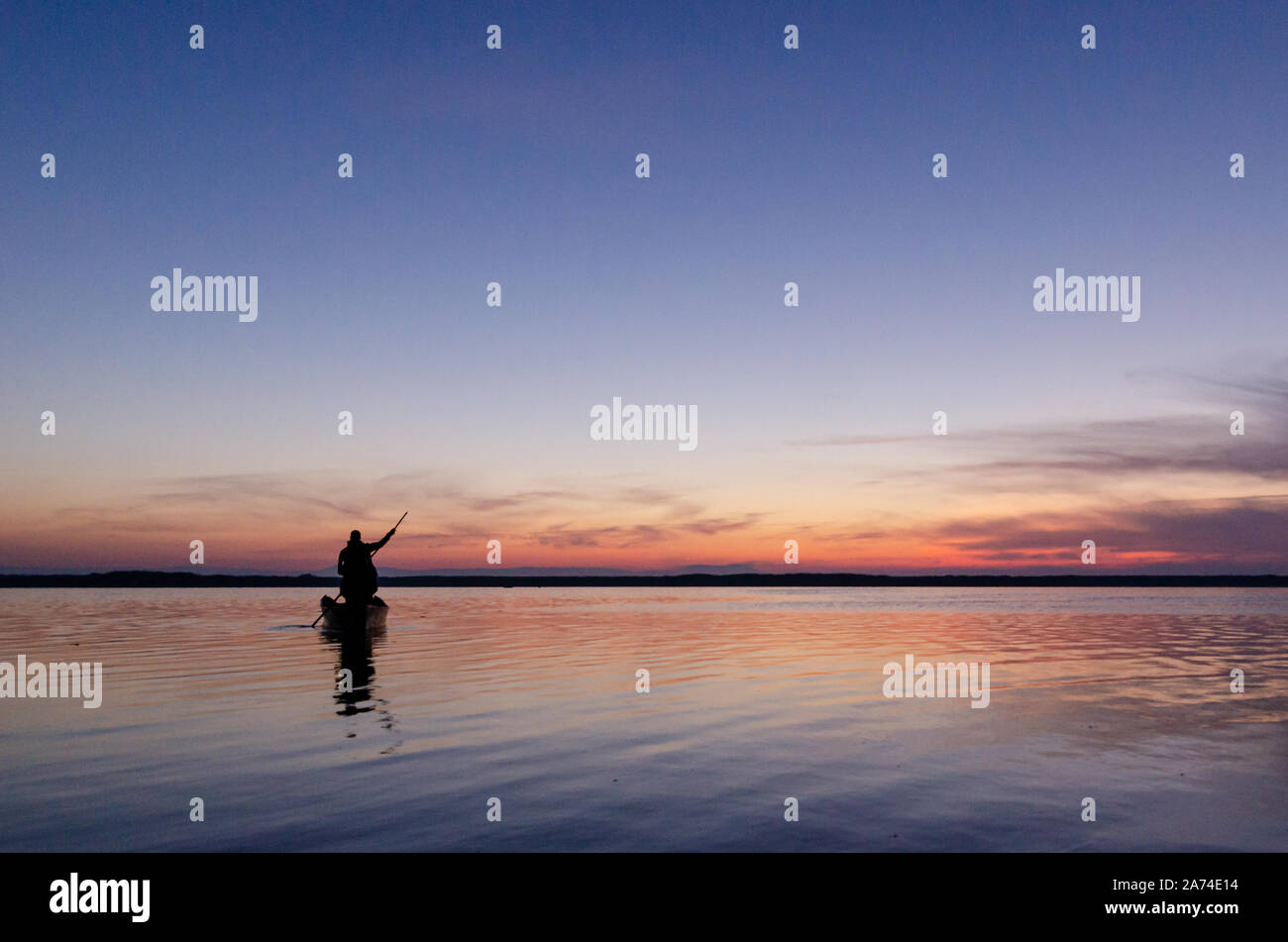 Silhouette of fishing boat and fisherman in the sunrise on the lake in ...