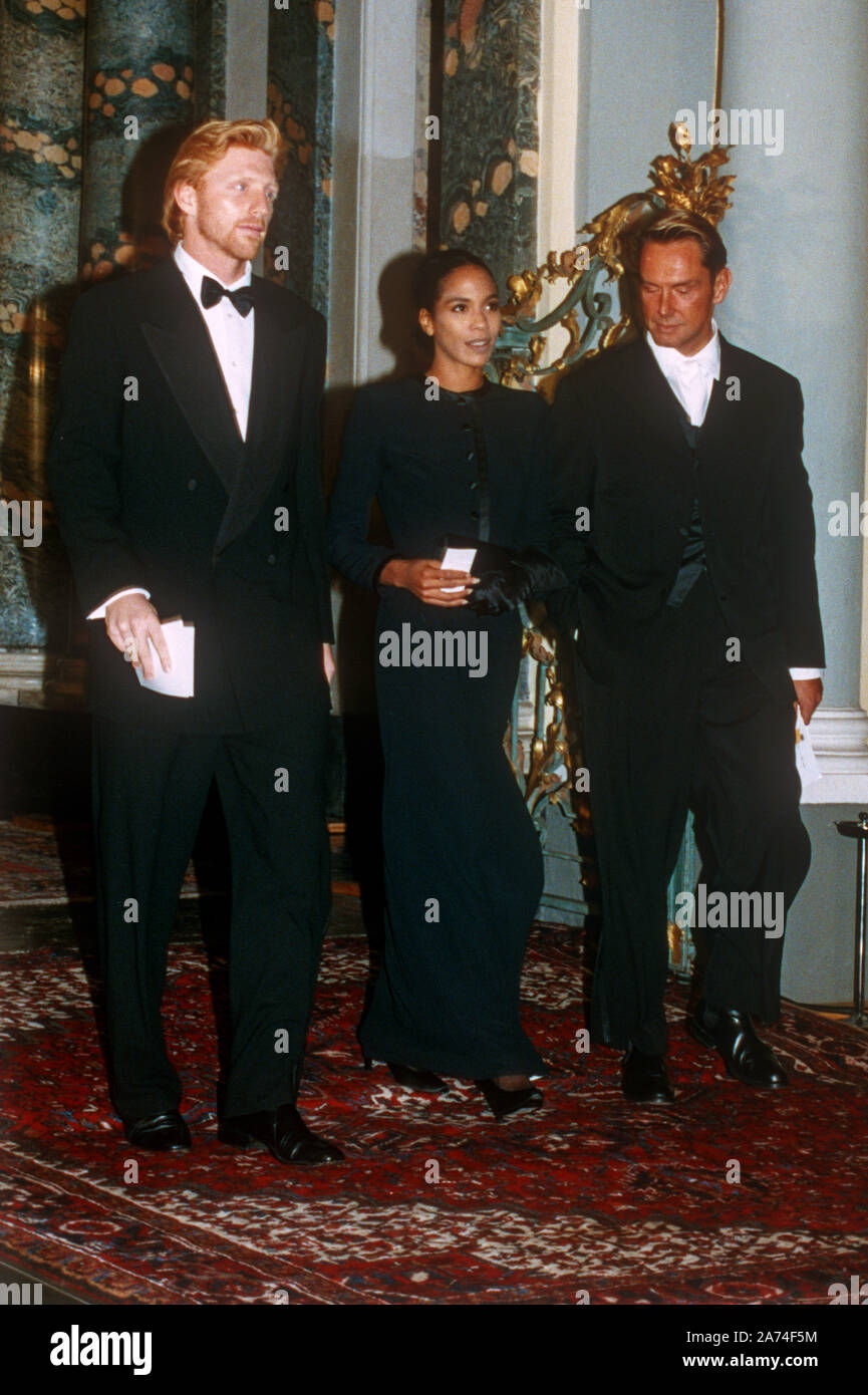 (L-r): Tennis star Boris Becker, his girlfriend Barbara Feltus-Ferbst and fashion designer Wolfgang Joop arrive in Bonn on 19 October 1992 for a festive banquet on the occasion of Queen Elizabeth II's visit to Germany. | usage worldwide Stock Photo