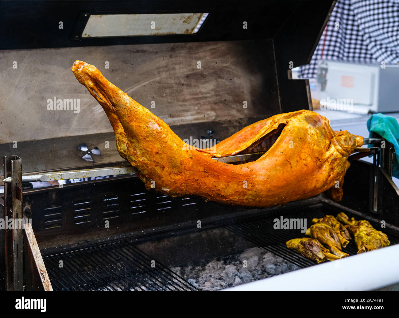 Roast Pig on Grill Spit at Night Market Stock Photo