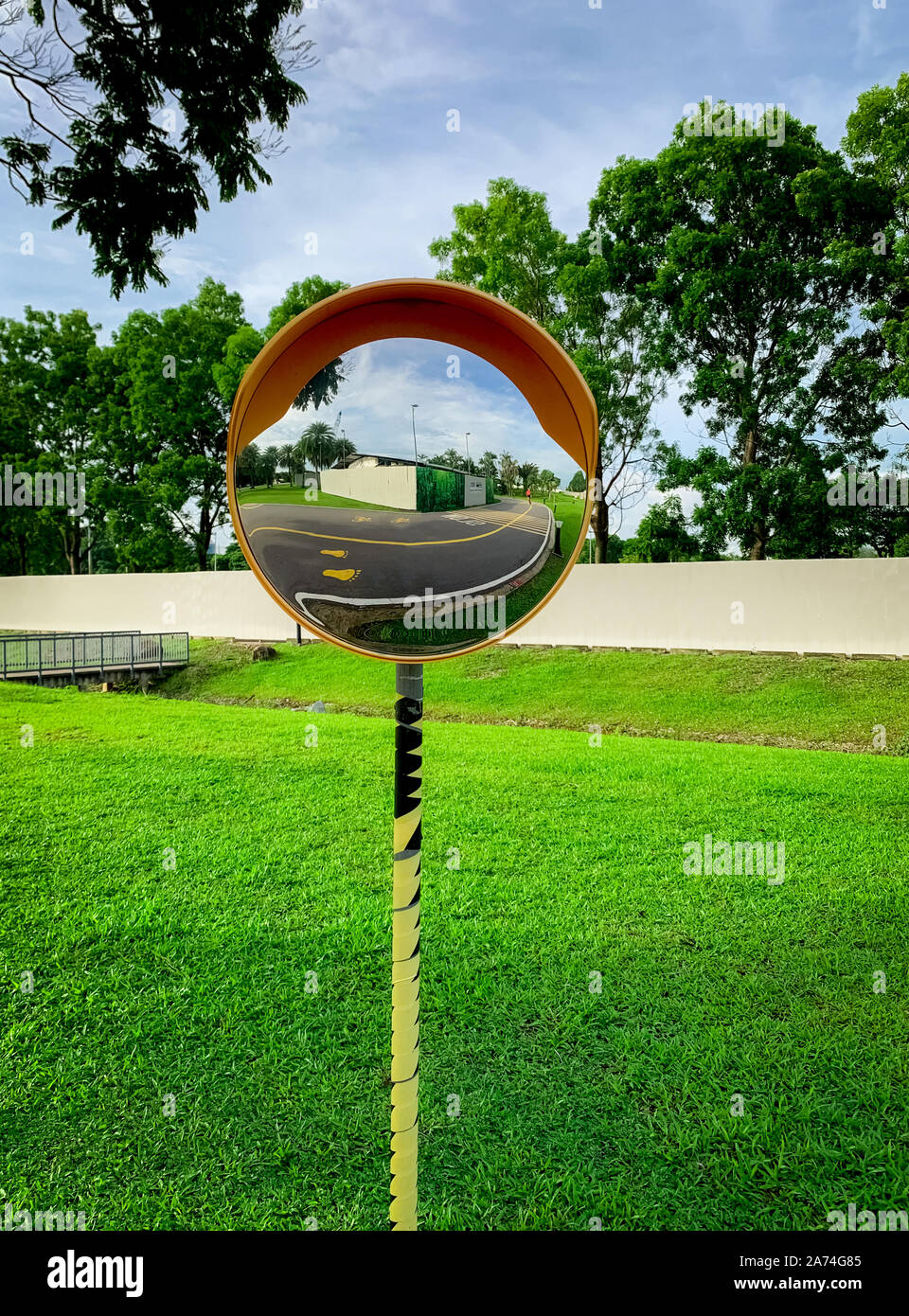 Convex safety mirror mounted on traffic pole at road curve. Asphalt road  reflected in mirror. Safety device for dangerous and narrow sharp curve road  Stock Photo - Alamy