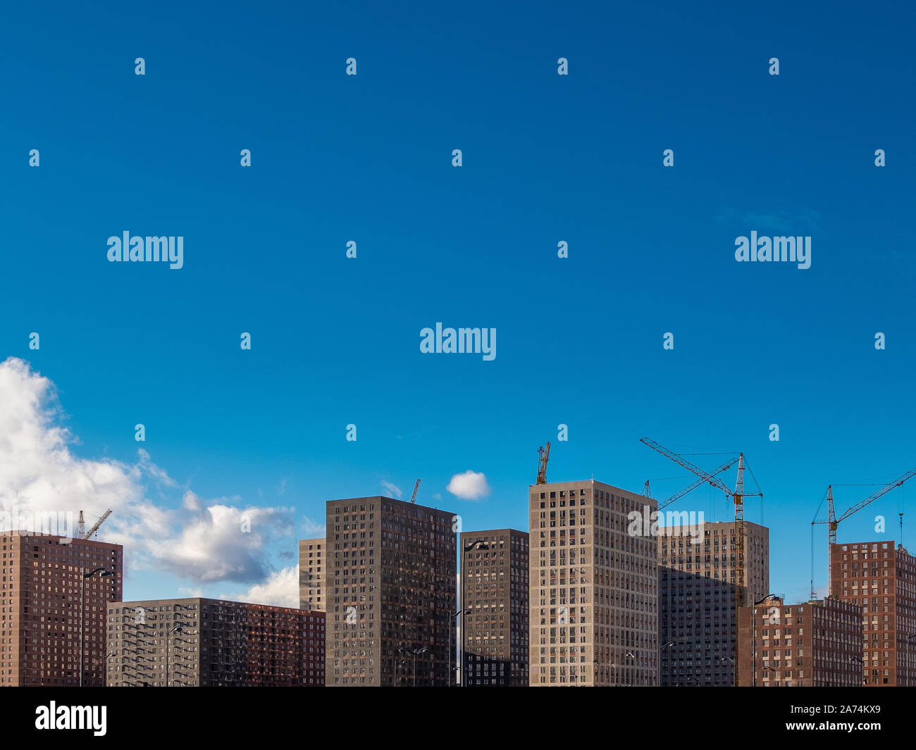 Construction cranes near residential buildings under construction in ...