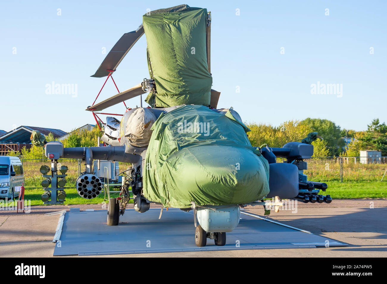 Military helicopter on the ground covered with a protective fabric cover Stock Photo